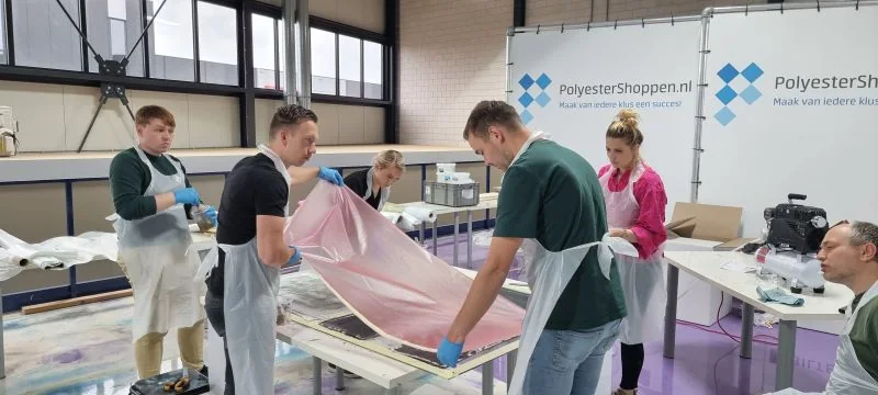 Deelnemers werken samen aan een project tijdens een workshop bij Polyestershoppen